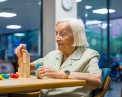 Portrait of a cheerful cute elder woman in a nursing home playing skill games